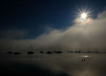 Sailboats in sea against sky