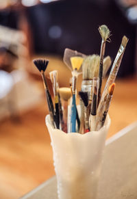 Close-up of paintbrushes in jar on table