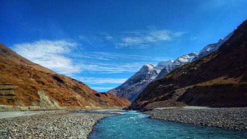Scenic view of lake and mountains against blue sky