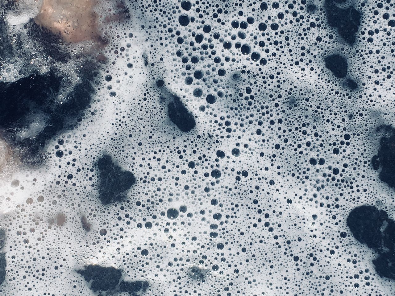 HIGH ANGLE VIEW OF BUBBLES ON WET GLASS