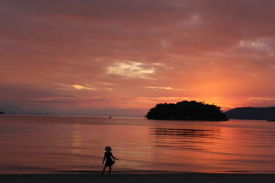 Silhouette man standing at sunset
