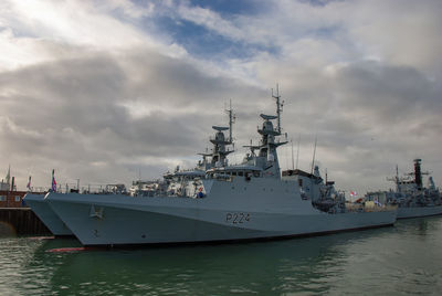 Ship moored at harbor against sky