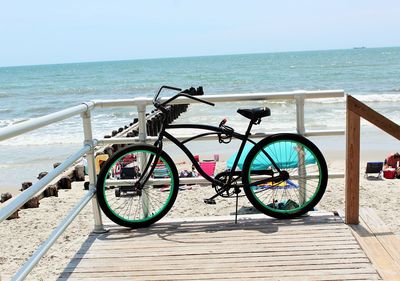 Bicycle by sea against clear sky