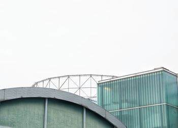 Low angle view of bridge against building against clear sky