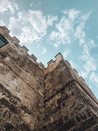 Low angle view of old building against cloudy sky