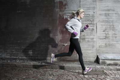 Full length of woman jogging on street