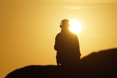 Silhouette person standing against sky during sunset