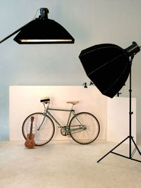 Flash lights against bicycle and guitar at photo studio