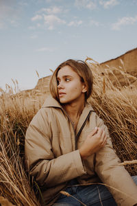 Portrait of young woman sitting on field