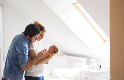 Parents cuddling with little baby at home