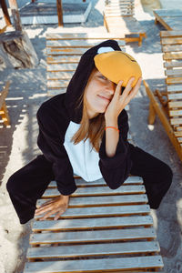Young woman wearing hat while sitting on staircase