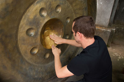 Mid adult man polishing metal in workshop