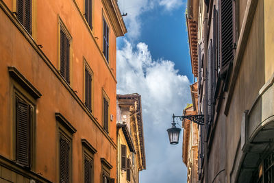 Low angle view of a  narrow alley through the streets and buildings of rome. italy.