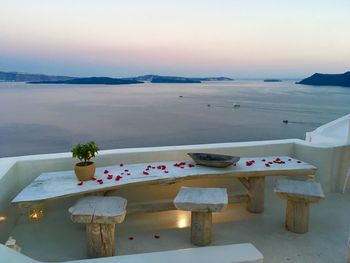 High angle view of table by sea against sky during sunset