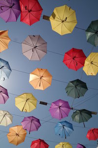 Low angle view of umbrellas hanging against sky