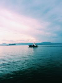 Ship sailing on sea against sky during sunset