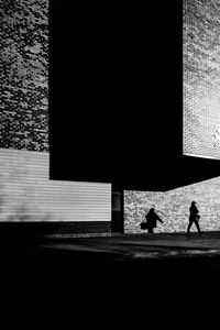 Silhouette people walking on footpath