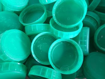 Full frame shot of green plastic bottle caps heap