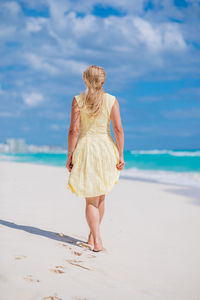 Rear view of woman walking at beach