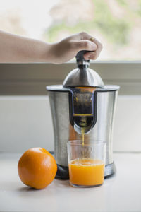 Close-up of hand doing orange juice