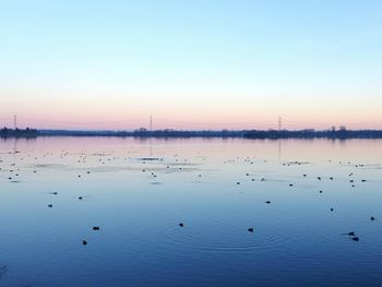Scenic view of lake against clear sky at sunset