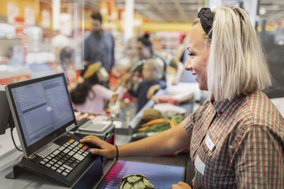 Smiling woman working at till