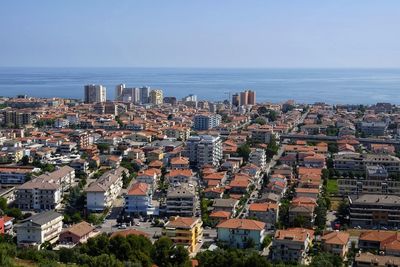 High angle view of buildings and sea against clear sky