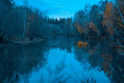 Scenic view of lake in forest against sky