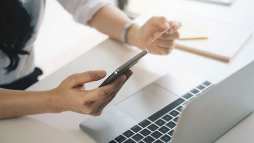Midsection of woman using mobile phone