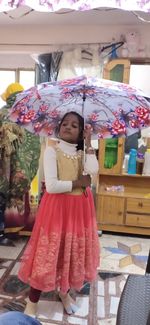 Portrait of cute girl standing in rain
