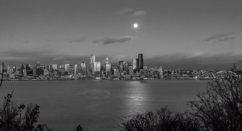 A bright full moon shines over the seattle skyline.