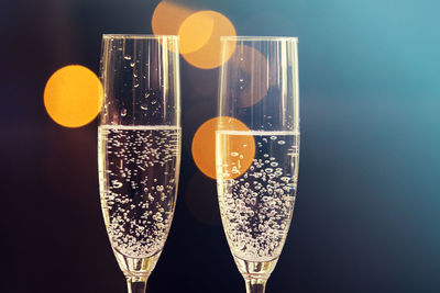 Close-up of wineglass on table against black background