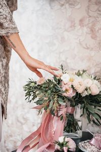 Midsection of touching bouquet during wedding ceremony 