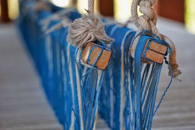 Close-up of blue thread weaving on loom in factory