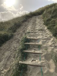 Dirt road on land against sky