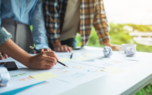 Midsection of business colleagues working on table