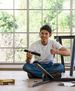 Portrait of smiling man sitting on floor