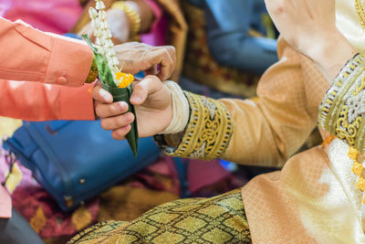 Midsection of woman holding bouquet during wedding festival