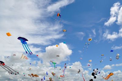 Low angle view of kites flying against sky