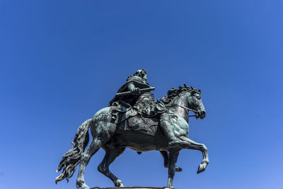 Low angle view of statue against clear blue sky