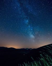 Scenic view of silhouette mountain against star field