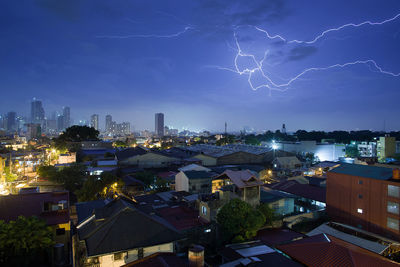 Illuminated buildings against sky at night