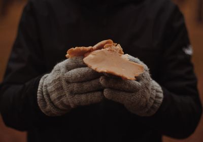 Midsection of man wearing gloves while holding meat