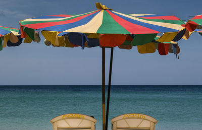 Low section of flags on beach against clear sky