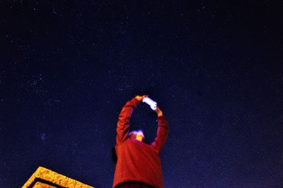 Person holding umbrella against star field at night