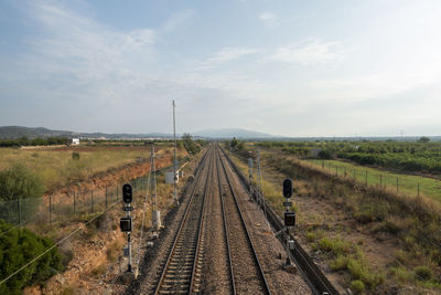 Railroad tracks on field against sky