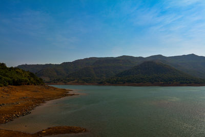 Scenic view of sea and mountains against sky