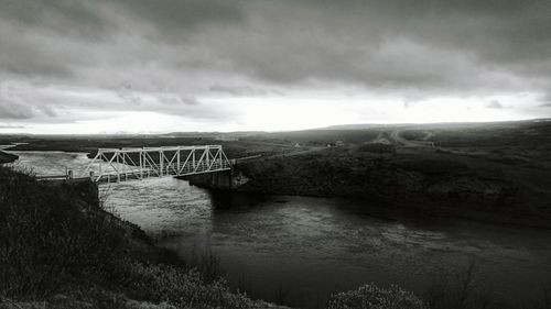 Scenic view of bridge over river against cloudy sky