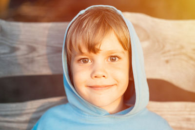 Portrait of face happy smiling candid five year old kid boy in blue hoodie in a hood