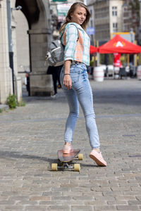 Rear view of woman walking on road